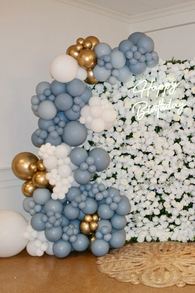 White Floral Wall with Gold and Blue Balloons